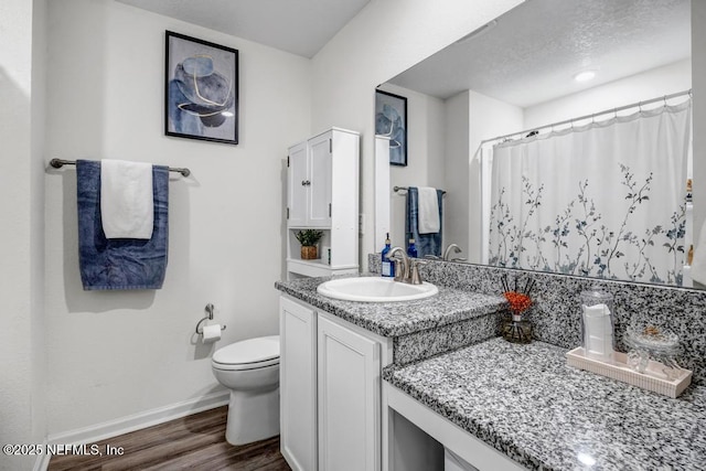 bathroom featuring hardwood / wood-style flooring, vanity, walk in shower, and toilet