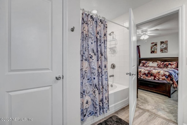 bathroom with hardwood / wood-style flooring, shower / tub combo, and ceiling fan