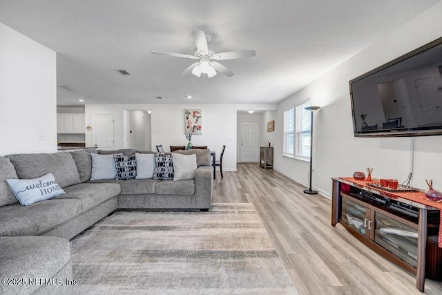 living room featuring ceiling fan and light hardwood / wood-style floors