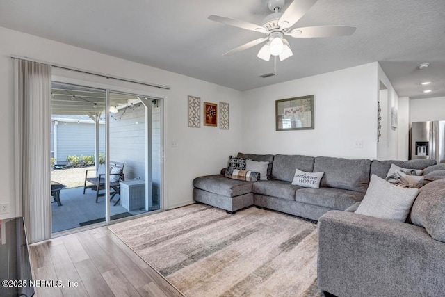 living room featuring ceiling fan and hardwood / wood-style floors