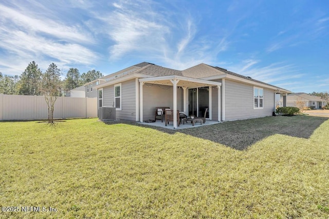 rear view of property with a lawn, central air condition unit, and a patio area