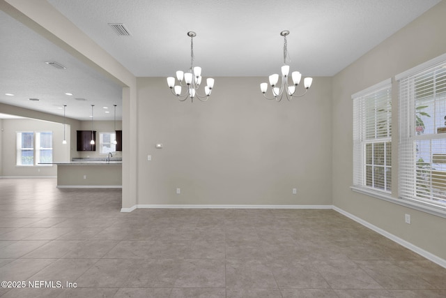 tiled spare room with an inviting chandelier and sink