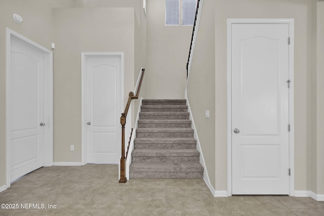 stairway with tile patterned floors