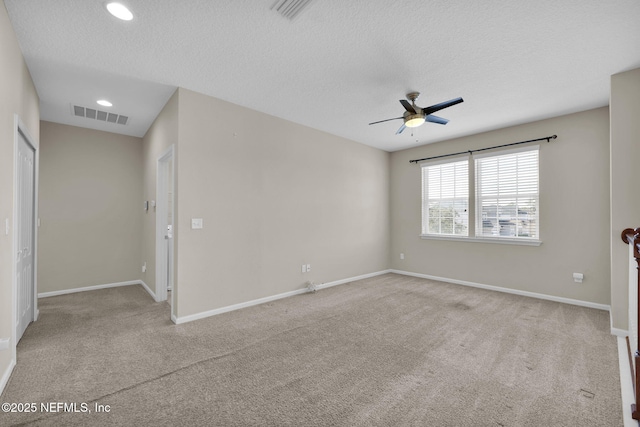 carpeted spare room with ceiling fan and a textured ceiling