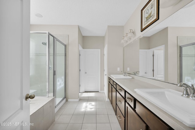 bathroom with independent shower and bath, vanity, tile patterned floors, and a textured ceiling