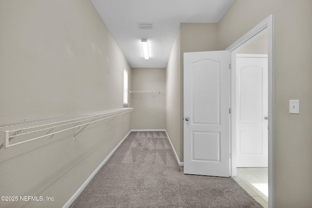 corridor featuring light colored carpet