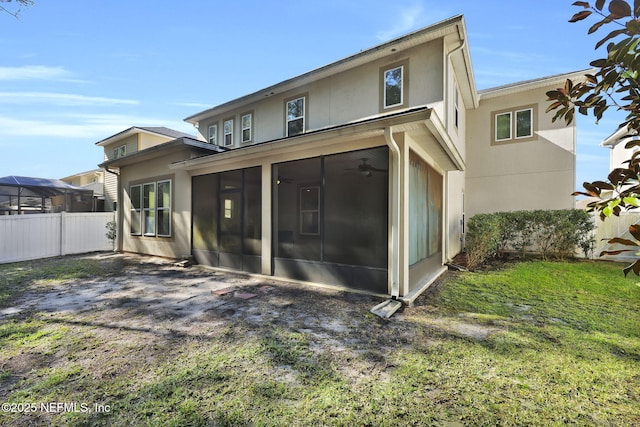 back of house featuring a yard, a sunroom, and ceiling fan