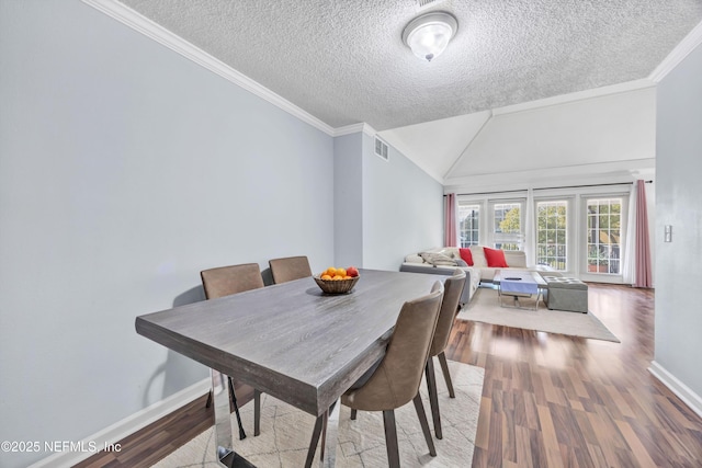 dining space featuring crown molding, a textured ceiling, and light hardwood / wood-style floors