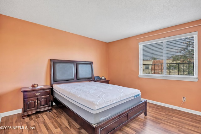 bedroom with wood-type flooring and a textured ceiling