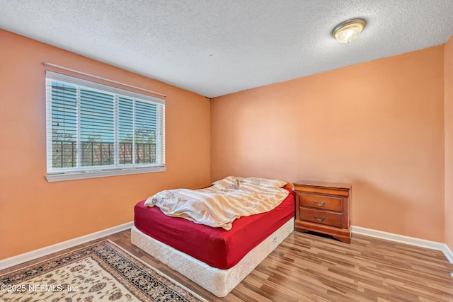 bedroom featuring wood-type flooring and a textured ceiling