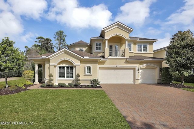 mediterranean / spanish home featuring a garage and a front lawn