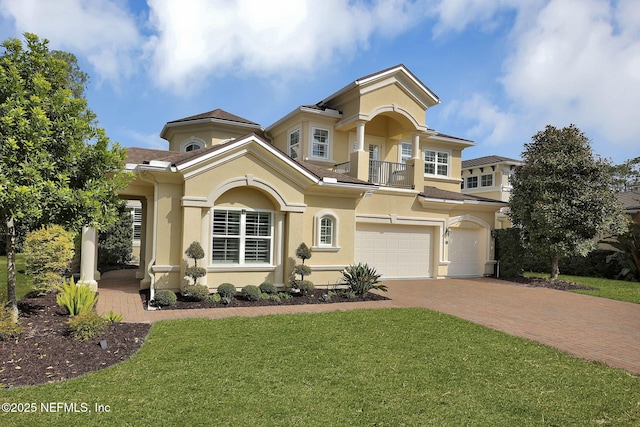 view of front of home featuring a garage, a balcony, and a front lawn