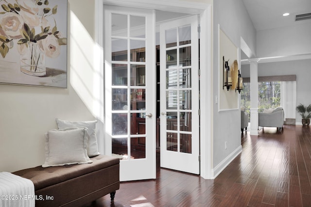 interior space featuring decorative columns, dark wood-type flooring, and french doors