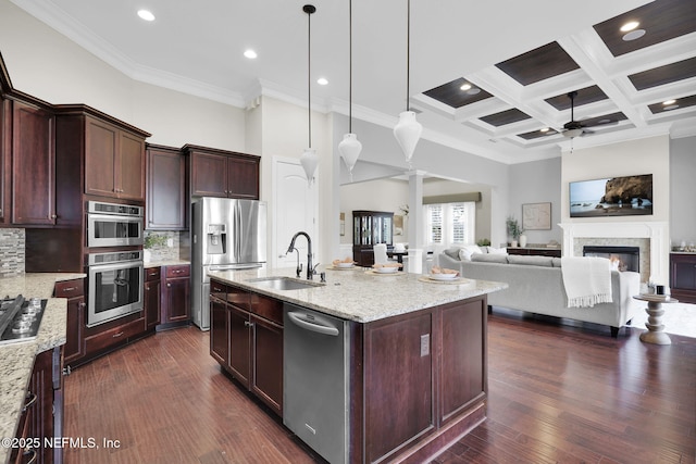 kitchen featuring pendant lighting, sink, a kitchen island with sink, light stone counters, and stainless steel appliances