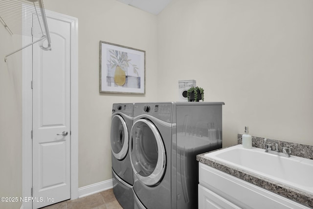 laundry room with washing machine and dryer, sink, and light tile patterned floors