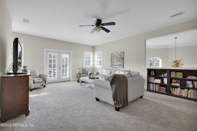 living room featuring light carpet, a textured ceiling, french doors, and ceiling fan