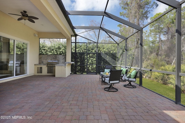 view of patio / terrace featuring an outdoor kitchen, a grill, and a lanai