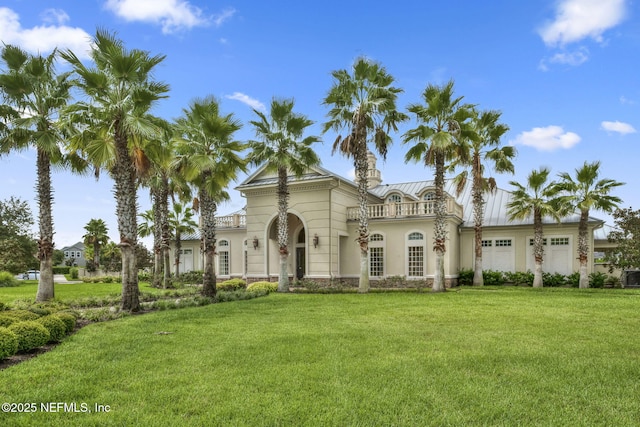 mediterranean / spanish-style house featuring a balcony, a garage, and a front lawn