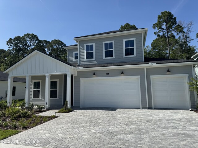 265 Dalton Mill Dr, Saint Johns, FL 32259 - view of front facade featuring decorative driveway, covered porch, an attached garage, and board and batten siding