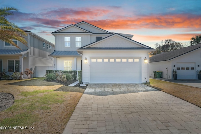 view of front of home with a garage and a lawn