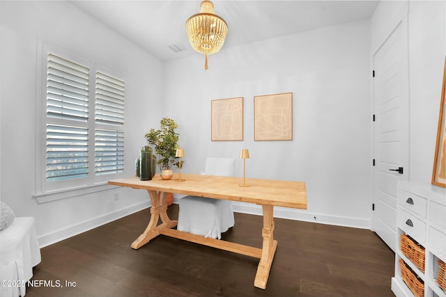 home office with dark hardwood / wood-style flooring and an inviting chandelier