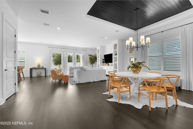 dining area featuring dark wood-type flooring, wooden ceiling, an inviting chandelier, and french doors