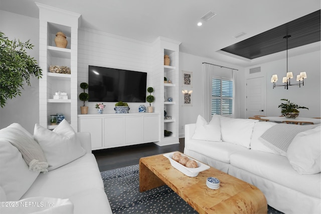 living room with an inviting chandelier and dark wood-type flooring