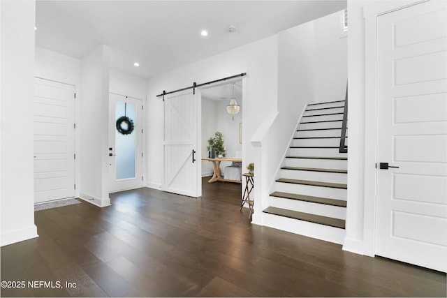 entryway featuring a barn door and dark hardwood / wood-style floors