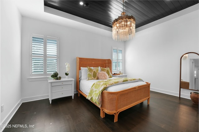 bedroom with dark hardwood / wood-style floors, wood ceiling, and an inviting chandelier