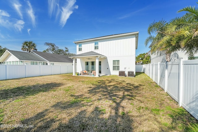 back of property with ceiling fan, a yard, central AC unit, and a patio