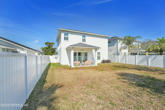 back of property featuring ceiling fan, a patio, and a lawn