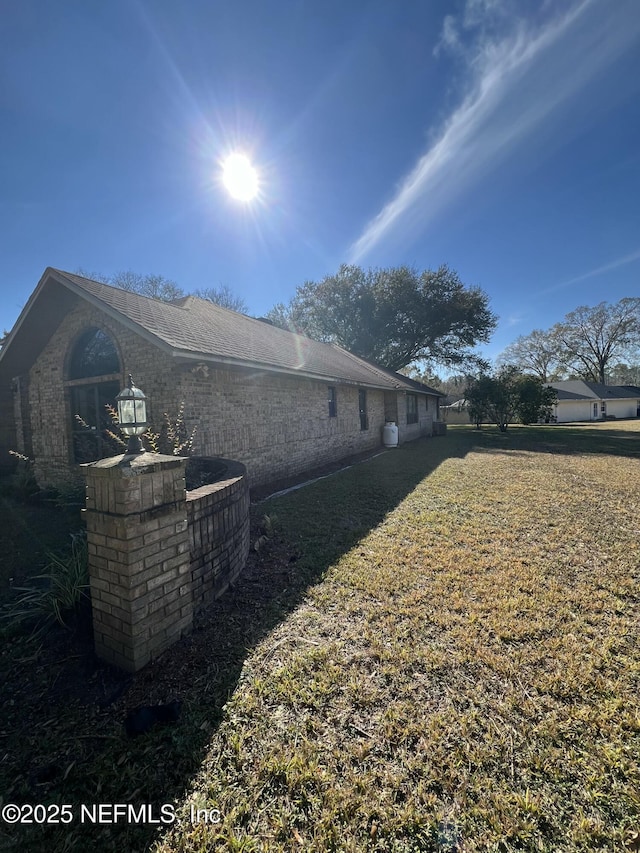 view of property exterior with central AC unit and a lawn