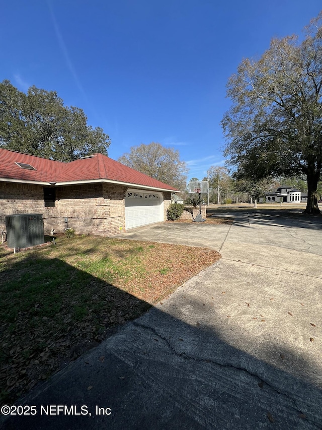 view of yard featuring a garage and central air condition unit