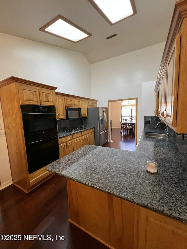 kitchen with sink, black appliances, and kitchen peninsula