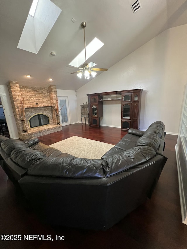 living room with lofted ceiling with skylight, wood-type flooring, and a fireplace