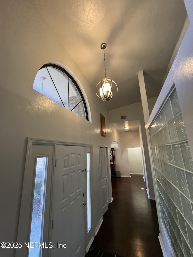 foyer entrance with dark hardwood / wood-style floors and a high ceiling