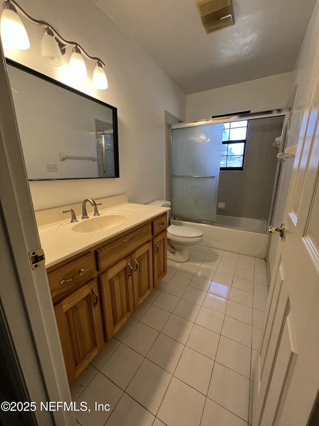 full bathroom featuring vanity, tile patterned floors, enclosed tub / shower combo, and toilet