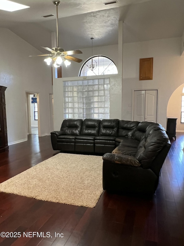 living room featuring ceiling fan, dark wood-type flooring, and high vaulted ceiling