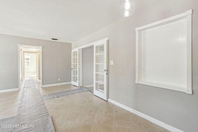 corridor featuring light tile patterned flooring and french doors