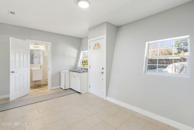 laundry room featuring sink and light tile patterned floors