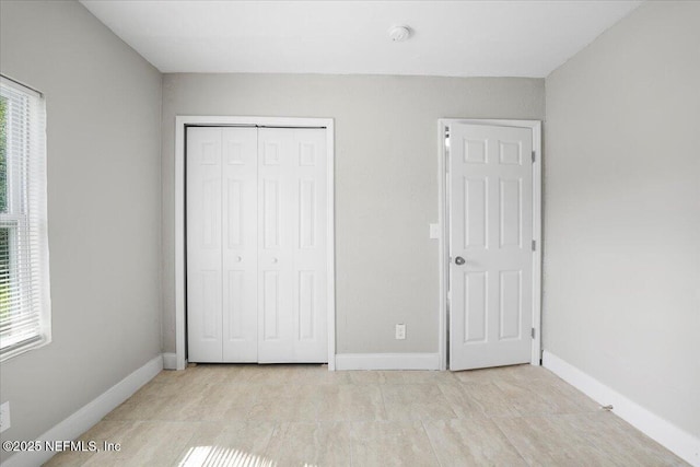 unfurnished bedroom with multiple windows and a closet