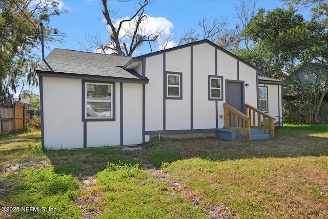 rear view of property featuring a lawn