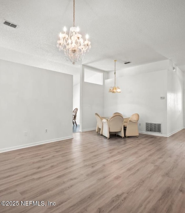 interior space featuring an inviting chandelier, hardwood / wood-style floors, and a textured ceiling