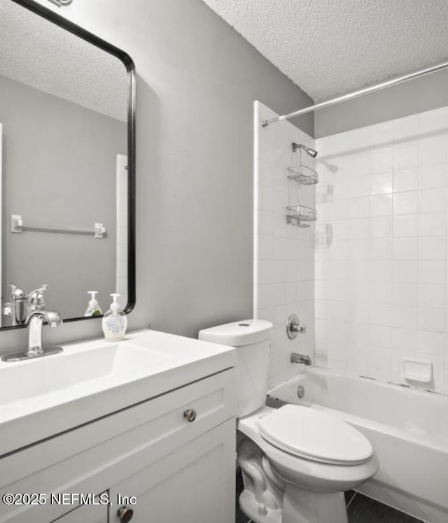 full bathroom with vanity, toilet, tiled shower / bath combo, and a textured ceiling