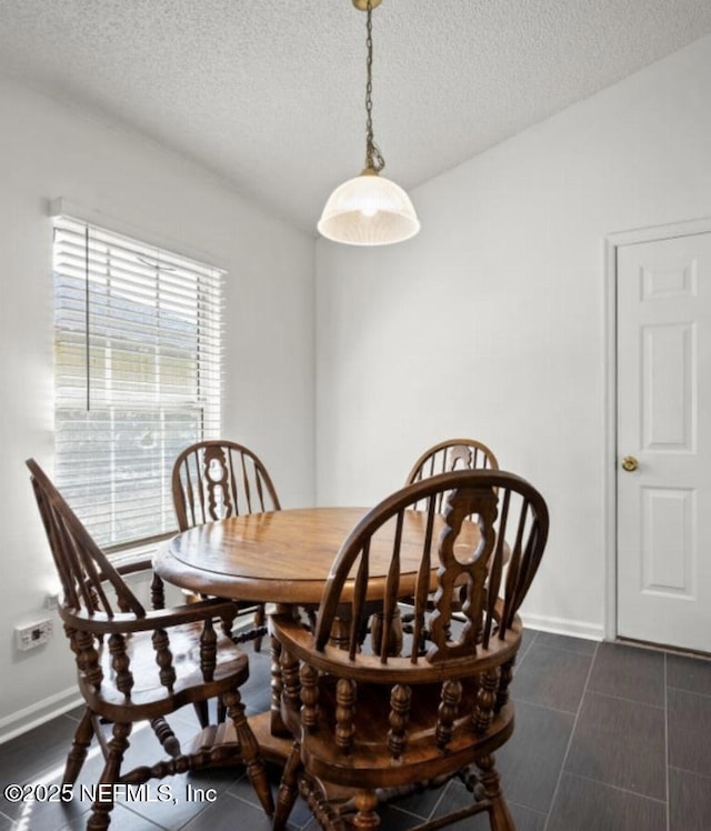 tiled dining room with a textured ceiling