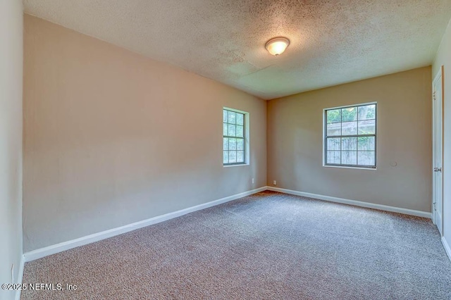 carpeted spare room featuring a textured ceiling