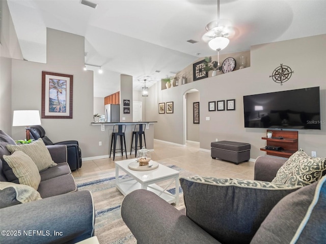 living room with ceiling fan, track lighting, vaulted ceiling, and light tile patterned floors