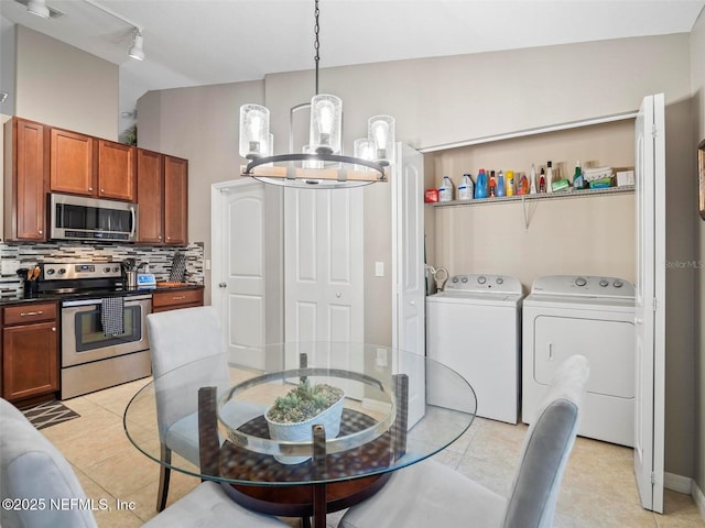 dining space with a chandelier, separate washer and dryer, and light tile patterned floors