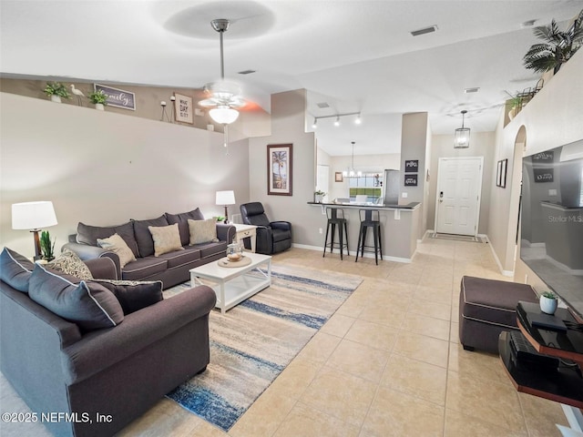 living room with lofted ceiling, light tile patterned floors, and ceiling fan