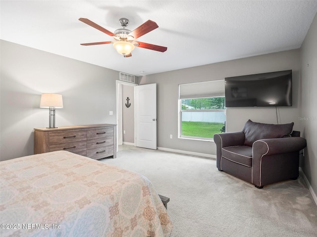 carpeted bedroom featuring ceiling fan and a textured ceiling